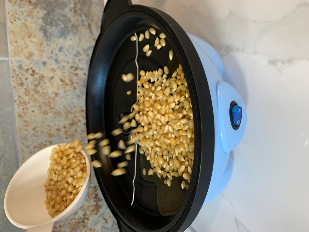 Pour the kernels onto the cooking surface. Rise by Dash Pouring Kernels
